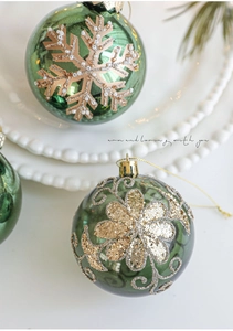 Macro detail of dark green glass Christmas ornaments with champagne gold snowflake glitter