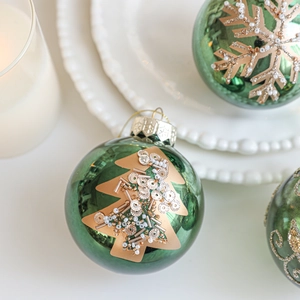 Glossy green Christmas ball with gold hand-painted tree and snowflake bead decorations