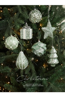 Detailed view of mint green glitter ornaments and faux pearls on a decorated Christmas tree