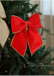 Dettaglio di fiocchi di Natale in velluto con bordi dorati su un albero addobbato