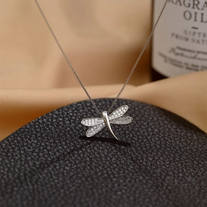 Macro shot of dragonfly pendant necklace featuring silver wings inlaid with white zircons