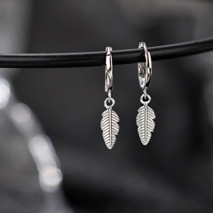 Silver feather pendant hoop earrings with detailed texture and elegant metallic luster
