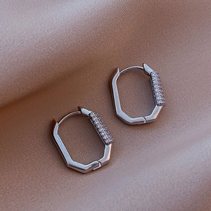 Elegant octagon silver hoop earrings featuring pavé set rhinestones on a silk background