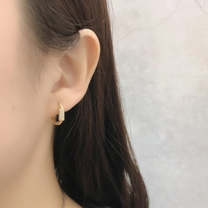Fashionable gold hoop earrings with sparkling zircon stones worn by a model