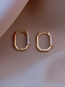 Macro shot of gold-plated octagonal hoop earrings with double row paved zircons