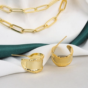 Dettaglio degli orecchini a cerchio dorati incisi S925 e della collana a catena coordinata