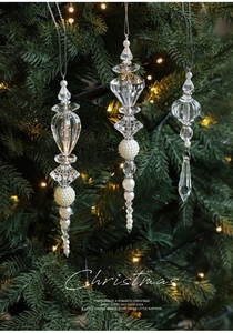 Close-up of clear acrylic icicle drops and white faux pearls on a glowing Christmas tree