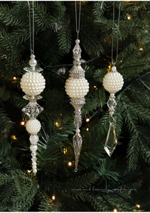 Detailed close-up of crystal Christmas ornaments with pearls on a lit tree