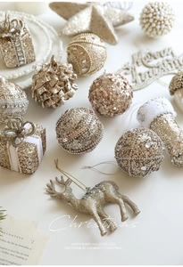 Detailed set of champagne gold Christmas ornaments featuring glitter balls and reindeer