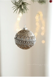 Macro view of gold glitter Christmas ball with silver lace and rhinestone detail
