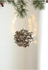 Macro detail of a champagne gold pinecone ornament with glitter on a Christmas tree