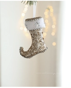 Detail of gold glitter Christmas stocking with white faux fur trim and silver star