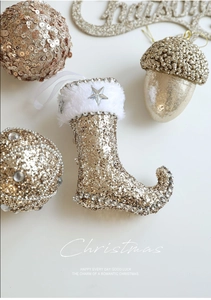 Close-up of champagne gold glitter Christmas ornaments including boot and acorn shapes