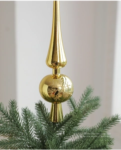 Dettaglio del puntale dorato per albero di Natale con fiocchi di neve su ramo di pino