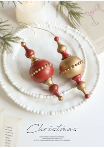 Close-up of vintage red and gold Christmas spindle ornaments with embossed bead details