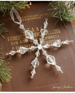 Gros plan de flocon de neige en acrylique avec perles sur un décor de livre rétro