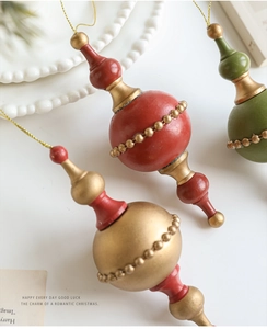 Detailed view of matte vintage teardrop ornaments with gold bead chain accents