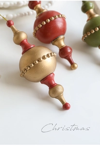 Macro detail of vintage finial Christmas ornaments in red, green and bronze with gold dots