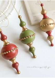Close-up of vintage finial ornaments in red green and gold with golden beaded detail