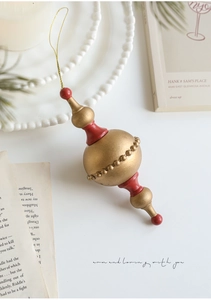Detail of a vintage red and gold teardrop Christmas ornament with golden hanging string