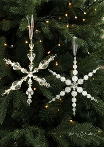 Gros plan de flocons de neige en acrylique sur un sapin de Noël aux lumières chaudes