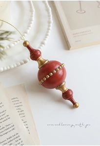 Detail of vintage terracotta and gold Christmas ornament on classic book pages