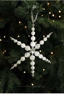 Vue détaillée d'une décoration flocon de neige en perles sur un sapin de Noël festif