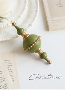 Detail of vintage olive green and gold wooden Christmas ornament with golden hanging string