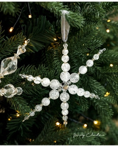 Gros plan d'un pendentif flocon de neige en acrylique transparent sur un sapin de Noël