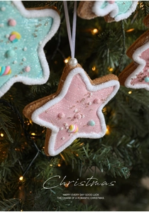 Close-up of pink star-shaped gingerbread style Christmas ornament with frosting and beads