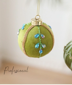 Détail de boule de Noël en velours vert de 8cm avec tresse dorée et cristaux bleus