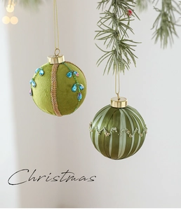 Détail de boules de Noël en velours vert et ruban avec dorures et perles fines