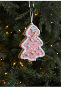 Pink Christmas tree ornament with glitter finish and white fur trim on a warm lit tree