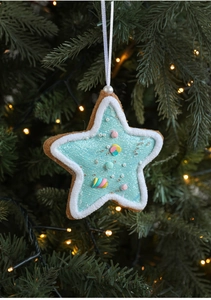 Close-up of a blue glitter star ornament with white plush trim on a warm Christmas tree