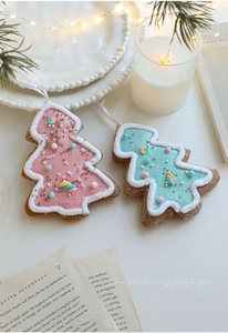 Detailed view of pink and teal star-topped Christmas tree ornaments with glitter and beads