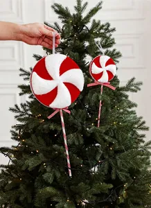 Détail de sucettes de Noël à rayures rouges et blanches avec paillettes sur un sapin décoré