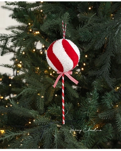 Gros plan d'un ornement sucre d'orge rayé rouge et blanc sur un sapin de Noël