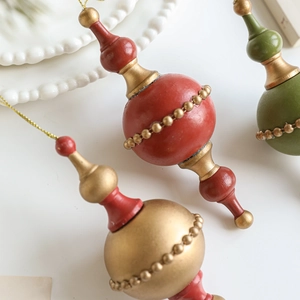 Vintage wooden Christmas ornaments in red green and gold with gold bead chain accents