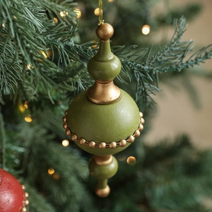 Vintage olive green and gold Christmas ornament hanging on a festive tree branch