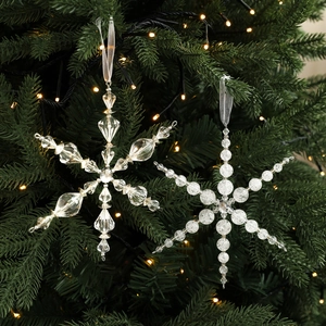 Décorations de flocon de neige en acrylique sur un sapin avec lumières chaudes