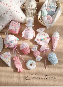 Pink Christmas dessert ornaments set featuring snowman, lollipop, and donut on a cozy table