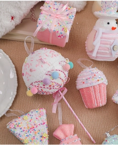 Detailed view of pink macaron and cupcake Christmas ornaments with glitter candy texture