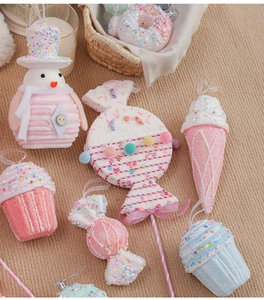 Detailed view of pink macaron Christmas ornaments with snowman and lollipop designs