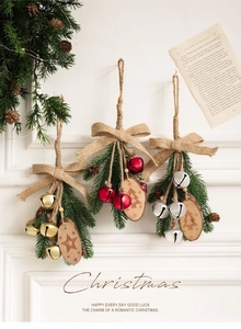 Detail of Christmas wooden ornaments with linen bows and colorful metal bells on white wall