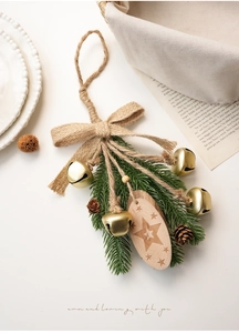 Detail of Christmas ornament with pine needles, golden bells and hemp rope bow