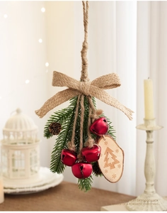 Detail of Christmas bell hanging ornament with pine cones, burlap rope and wooden tag