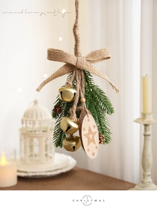 Macro detail of Christmas pine cone pendant with wood slice, golden bells, and burlap bow