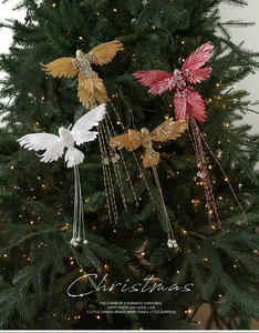 Close-up of artificial birds with pearls and tassels on green Christmas tree branches