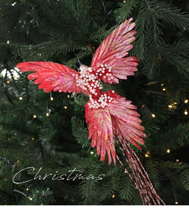 Detail of red Christmas bird ornament with beads and long tassel on festive tree