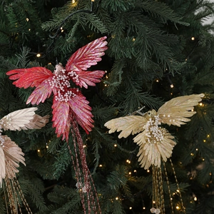 Glittery bird Christmas ornaments with feathers and clips on a decorated tree
